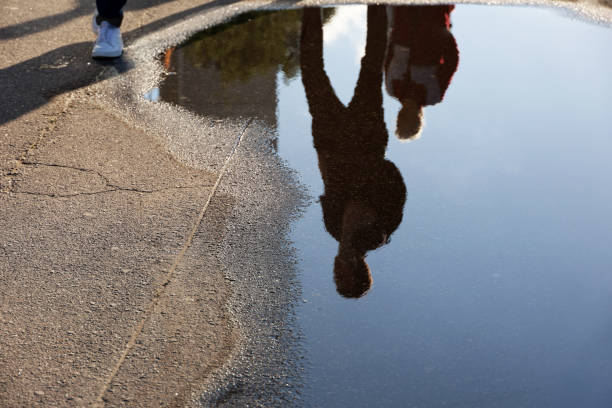 istock Defocused view to people reflection in puddle on a street 1401477597
