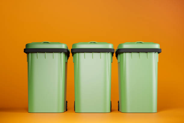 istock Green garbage bins on orange background, 3d render illustration. 1401478359