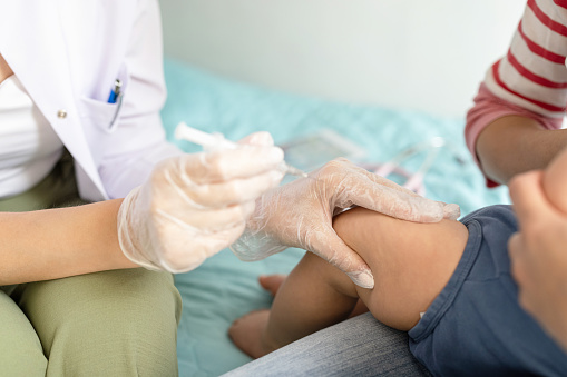 Toddler getting injection shot at home