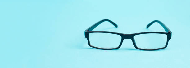 istock Eyeglasses with a black frame on a blue background, copy space for text 1401479874