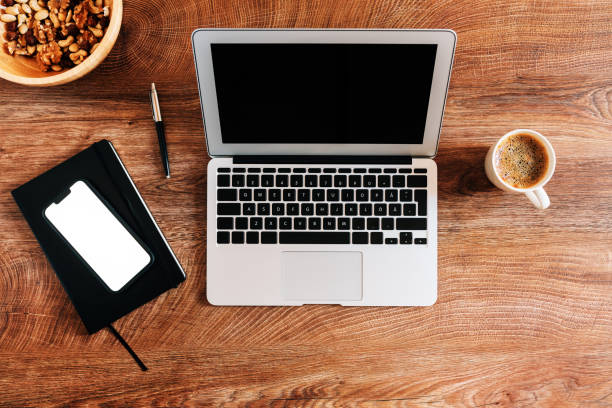 Working at home concept, top view of workspace with laptop computer and smartphone mockup screen on the desk