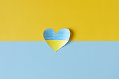 Top view of Ukraine flag painted heart shaped isolated on yellow, blue background. symbol of help, support and no war in Ukraine.