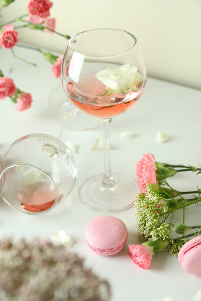istock Wine, sweet food and flowers on white table 1401482865