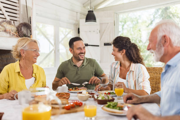 식탁에서 식사를 하는 동안 부모와 이야기하는 행복한 성인 자식. - family dining table breakfast eating 뉴스 사진 이미지