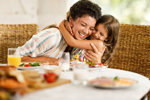 istock Happy single mother and daughter embracing during breakfast at home. 1401484977