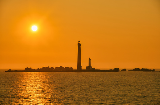 View of a beautiful sunset next to a lighthouse on the Normandy coast in France.