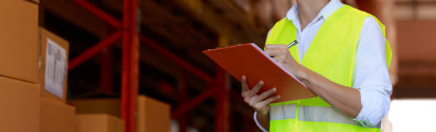 work man checking inventory in stock room on clip board chart, quality controller, panorama banner size, warehouse factory concept. work man checking inventory in stock room on clip board chart, quality controller, panorama banner size, warehouse factory concept. customs officer stock pictures, royalty-free photos & images