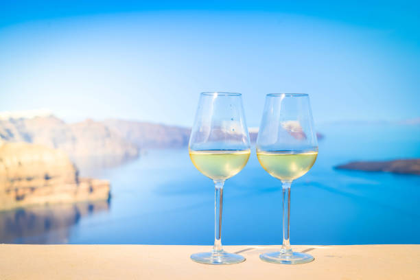 two glasses of white wine with Aegaen sea in background, Greece