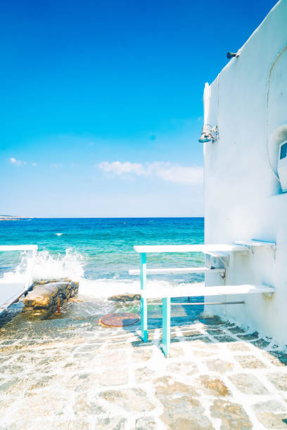 Naoussa typical white street leading to sea, small village on Paros island, Greece