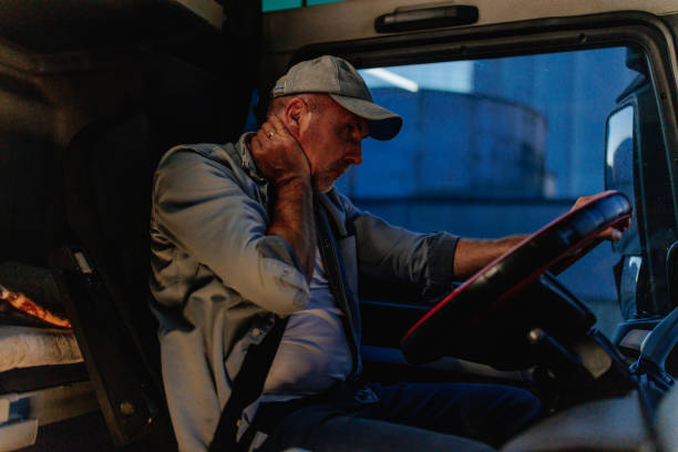 istock Tired truck driver massaging neck while driving 1401492867