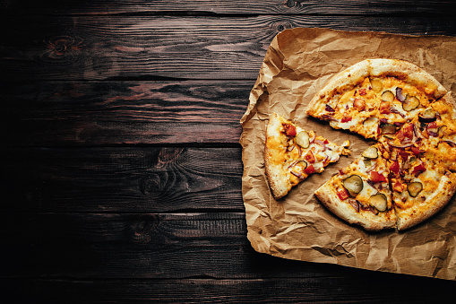 Pizza on wooden background top view close up