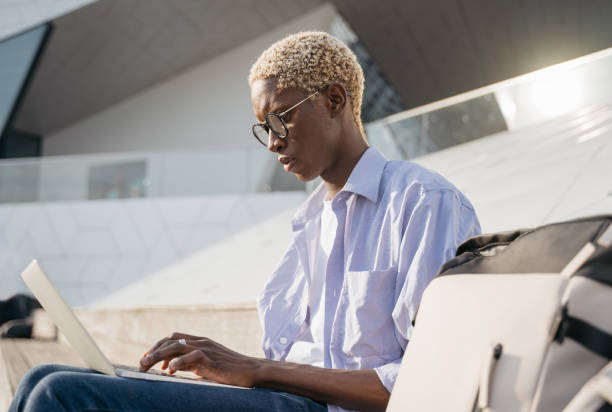 istock African American freelancer using laptop computer typing working online sitting at workplace. Handsome stylish student studying sitting in university campus, online education concept 1401495163