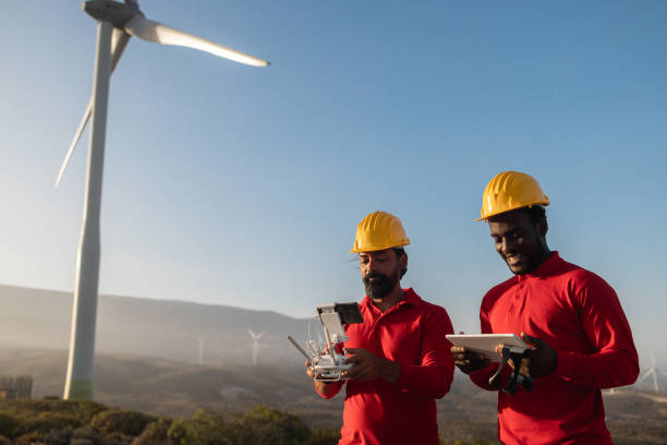 istock Multiracial engineer men working on windmill farm with digital tablet and drone - Renewable energy concept 1401495537