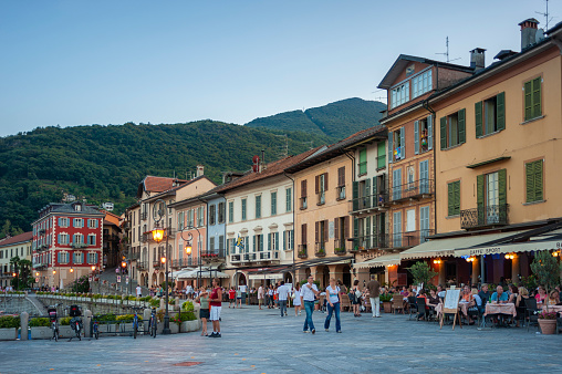 Cannobio, Italy - August 18, 2018: Historic house facades in Cannobio with restaurants along the promenade of Lake Maggiore. Cannobio is a town in Piedmont in northern Italy
