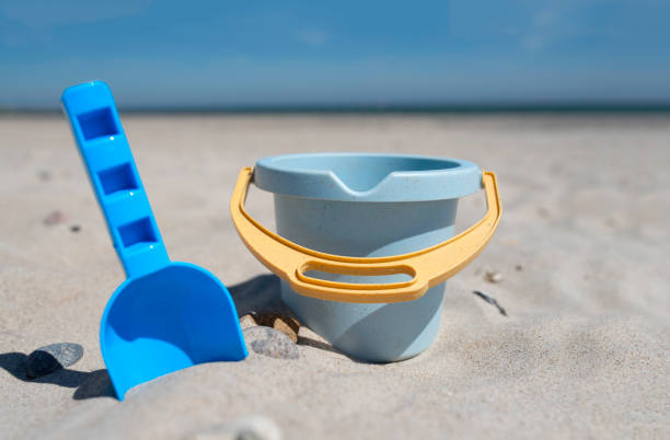close-up view of toy bucket and spade on sand beach stock photo