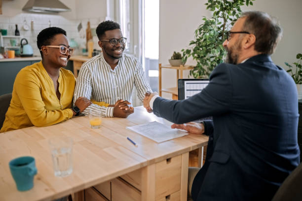 We're sure that you'll get us the best deal Shot of a handsome young man shaking hands with a financial advisor during a consultation at home bank manager stock pictures, royalty-free photos & images