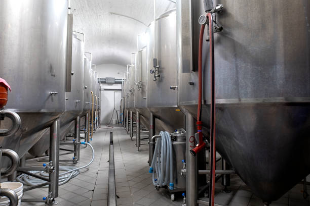 Craft brewery tanks and pipes with manometers in private microbrewery. Industrial interior of modern craft brewery with chrome cylindrical metal beer tanks. Private microbrewery. pasteurization stock pictures, royalty-free photos & images
