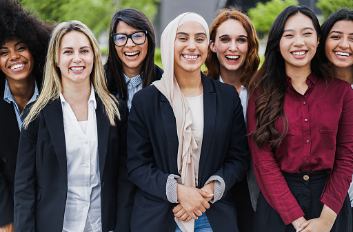 Colegas de negocios multiétnicas sonriendo en la cámara al aire libre - Enfoque en la cara de la niña musulmana photo