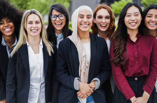 des collègues femmes d’affaires multiethniques souriant à la caméra en plein air - focus sur le visage d’une fille musulmane - vêtement modeste photos et images de collection