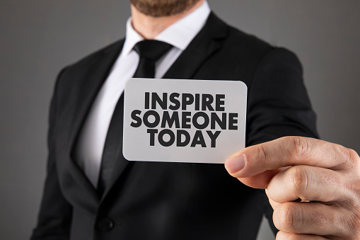 Businessman is giving his business card with inspire someone today text