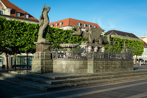 Austria, carinthia, Klagenfurt. The Lindwurm fountain, representing the Lindwurm dragon, about to be slayed by Hercules, is located in the center of Klagenfurt, on the Neuer Platz. The Lindwurm sculpture hails from the 16th century, the Hercules figure was added in the 17th century.