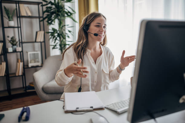 istock Young woman using computer and working at home office with headphones on 1401500274