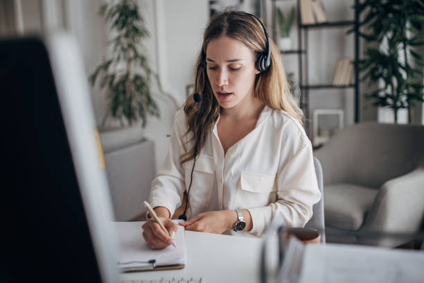 istock Young woman using computer and working at home office with headphones on 1401500349