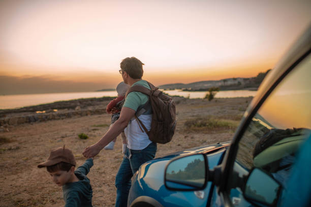 istock Man with son and daughter enjoying sunset on the beach 1401502718