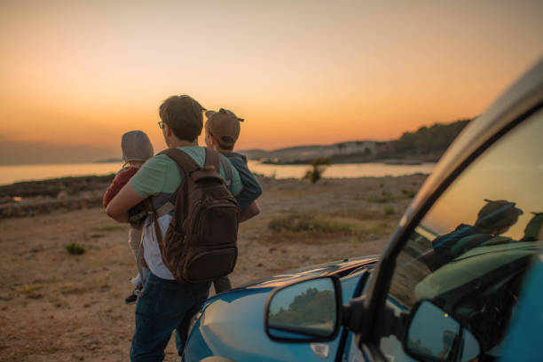 istock Man with son and daughter enjoying sunset on the beach 1401502787