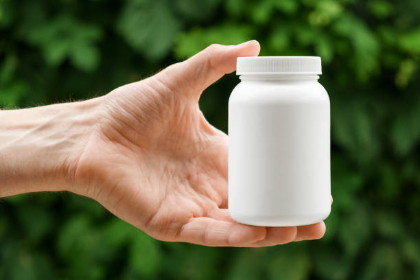 istock A white container with lid in man's hand. Close up, copy space, place for label or branding. 1401509913