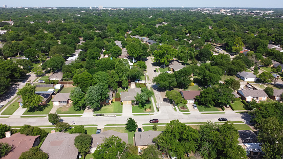 Established residential neighborhood with lush greenery to horizontal aerial view Richardson, Texas, USA. Typical single family houses with matured trees and large backyard