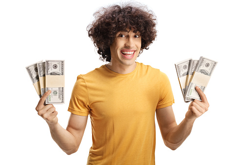 Smiling guy showing cash in front of camera isolated on white background