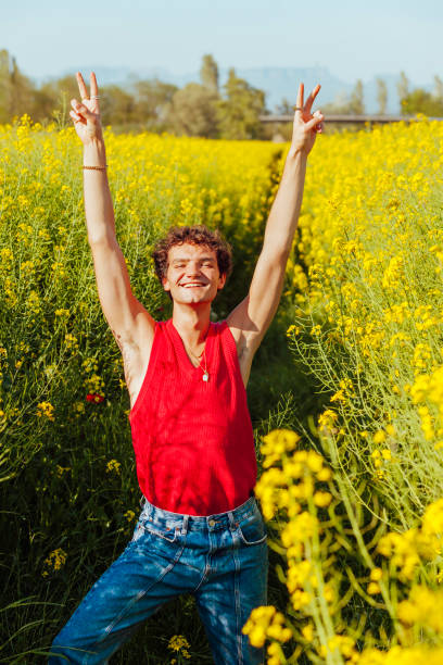 istock Young cheerful boy doing peace sign at yellow field 1401516655