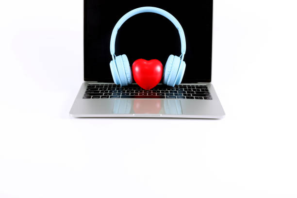 istock Light blue headphone with red heart placed on a laptop isolated on white background have copy space. 1401519462