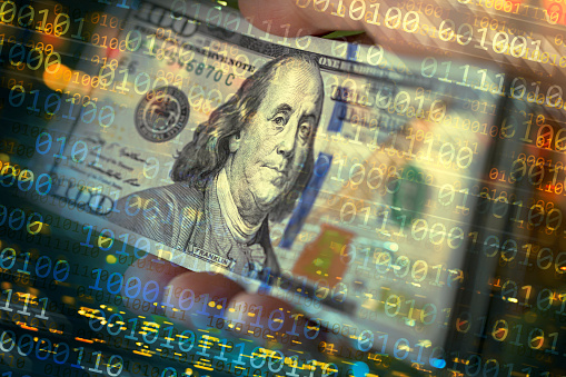 Binary code abstract background with US $100 dollar banknotes in hand. Shallow depth of field.