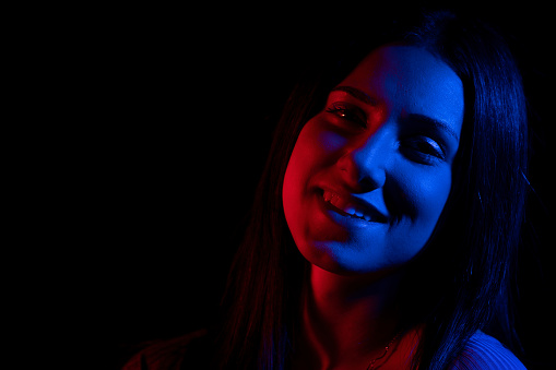Woman with red and dark blue gel lighting. Woman with color magic studio flash filters.
