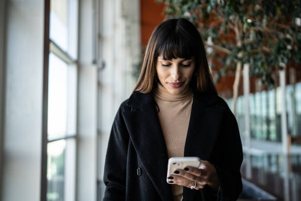 istock Young woman using smartphone in an airport 1401521458