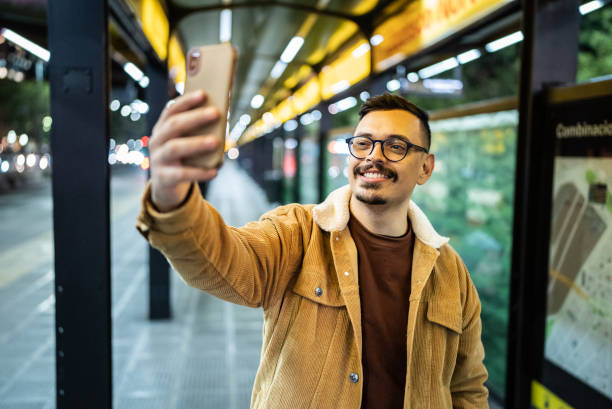 istock Happy man taking a selfie in a bus stop 1401521643