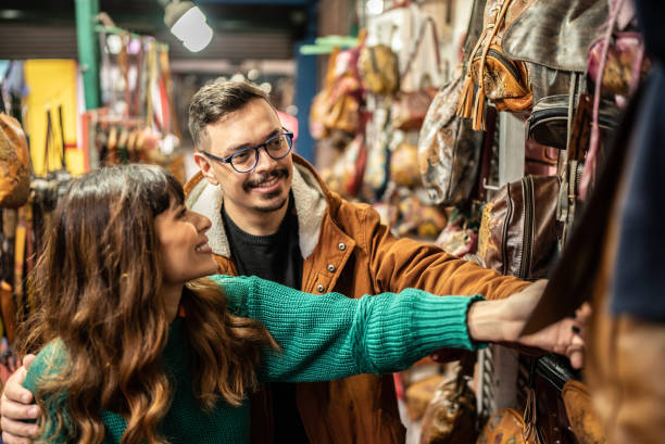 Young couple shopping in a thrift store Young couple shopping in a thrift store tourist couple candid travel stock pictures, royalty-free photos & images