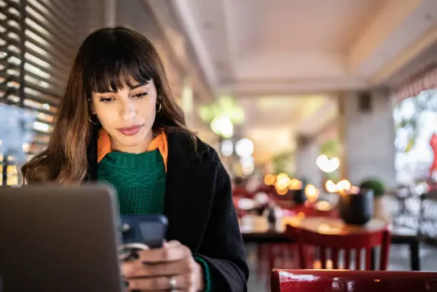 Photo of Businesswoman working using smartphone in a restaurant