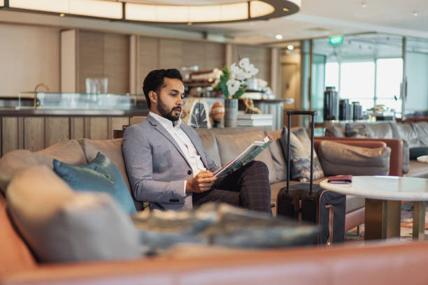 geschäftsreisen - indischer geschäftsmann wartet in einer flughafenlounge - business travel travel airport lounge airport stock-fotos und bilder