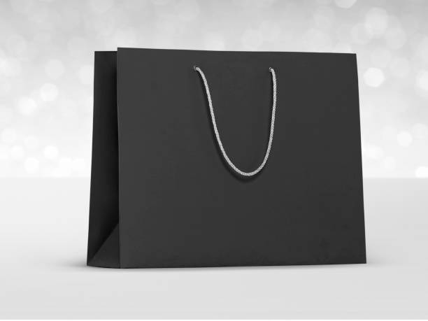 istock Black paper bag on white shining bokeh background. concept for choosing best 1401523988