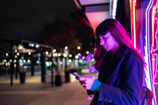 Young woman using the mobile phone in the street