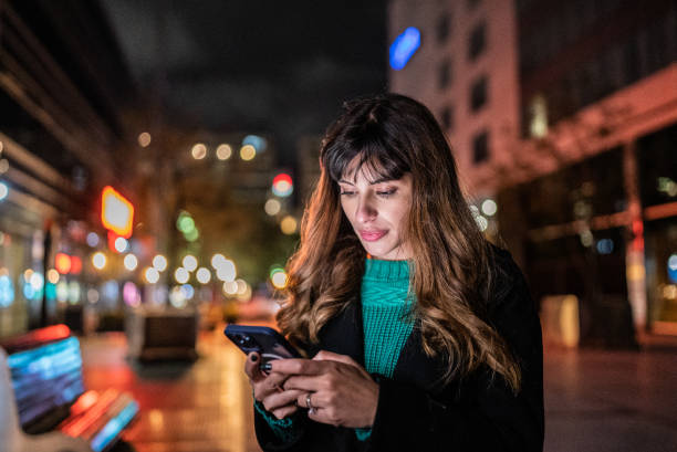 istock Young woman using the mobile phone in the street 1401524441