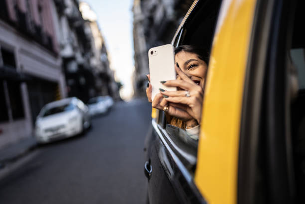 молодая женщина снимает или фотографирует вид на мобильный телефон в такси - taxi buenos aires people city стоковые фото и изображения