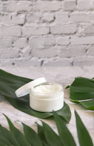 istock White jar and monstera leaves on marble table close up. Brand packaging mockup 1401525975