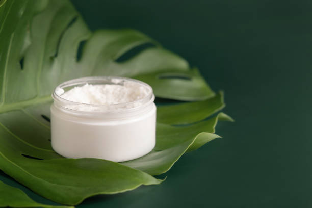 istock White jar on monstera leaf on green table close up. Brand packaging mockup 1401525991