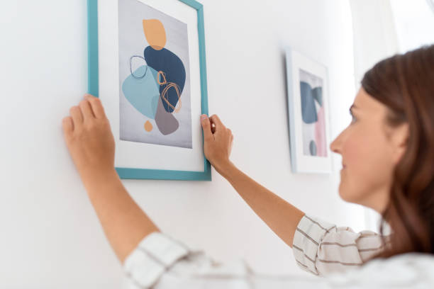istock woman decorating home with picture in frame 1401527030