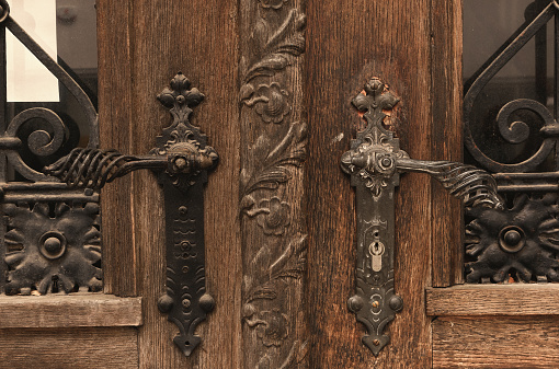 The exterior of the old wooden decorated door. View on the details.