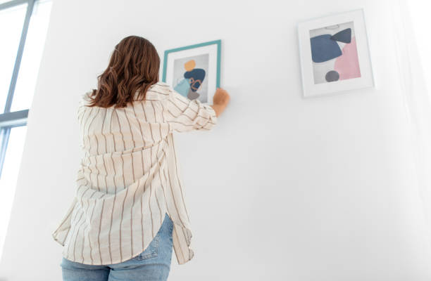 istock woman decorating home with picture in frame 1401527659